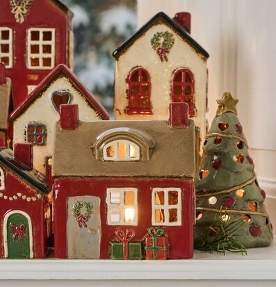 Bild av dekorativa ljuslyktor och keramik i vinterfönster