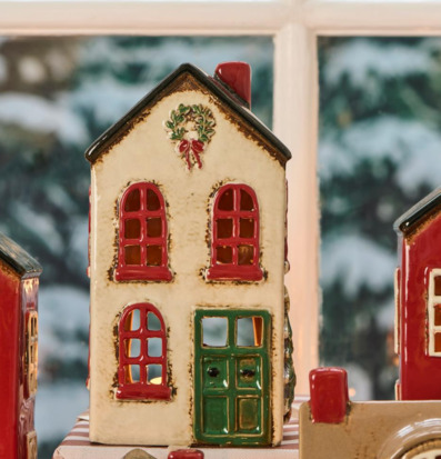 Bild av husformad ljuslykta med julkrans och vinterkänsla