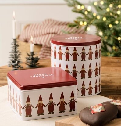 Bild av juligt stilleben med plåtburkar, gran och bakverk