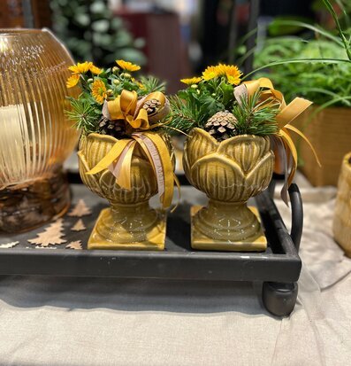 Bild med pokalkrukor, blommor och dekor på metallbricka