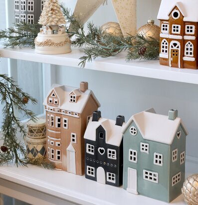 Bild av juldekorerad hylla med huslyktor och vinterdetaljer