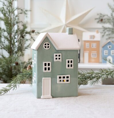 Bild av ljuslykta i form av hus i vinterinspirerad miljö