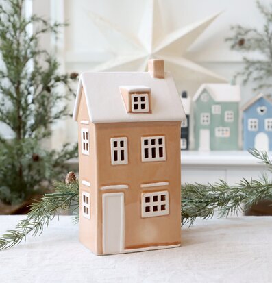 Bild av dekorativt puderrosa ljuslykta-hus i vintermiljö