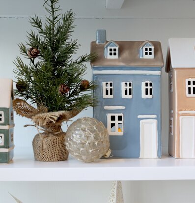 Bild: Dekorativa keramikhus och vinterinspirerad hylla hemma