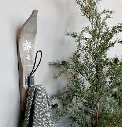 Bild med vinterinspirerad krok, filt och barrväxt i harmoni