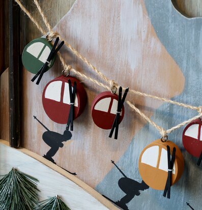 Bild av trätavla med skidlift och vinterlandskap i närbild