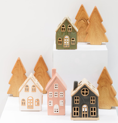 Bild av dekorativa keramikhus och trägranar i vintrig miljö