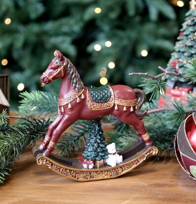 Bild av dekorativ gunghäst i julmiljö med gran och detaljer