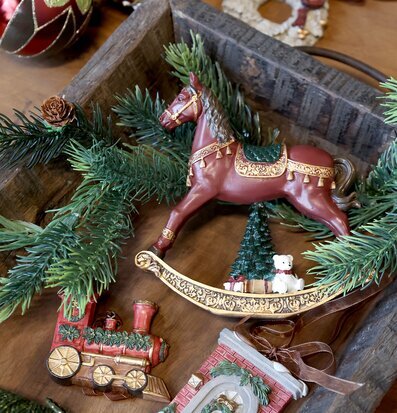 Bild av juldekorationer med gunghäst, gran och röda kulor