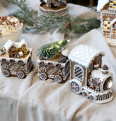 Bild av dekorativt jultåg med pepparkakshus och julgran