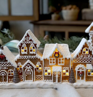 Bild av pepparkakshus med LED-belysning i mysig vintermiljö