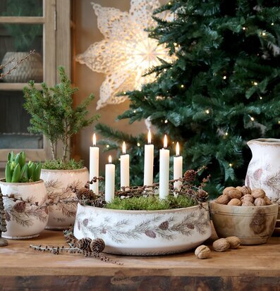 Bild på rustikt vinterbord med krukor, ljus och naturinslag