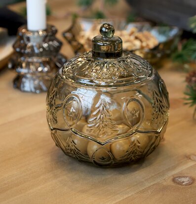 Bild på dekorativ glasburk och julig dukning i varm miljö