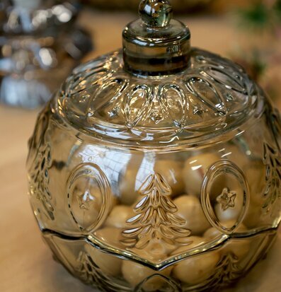 Bild på dekorativ glasburk med julmotiv i varm hemmiljö