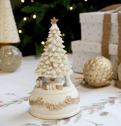 Bild med julgran speldosa och stämningsfull juldekoration