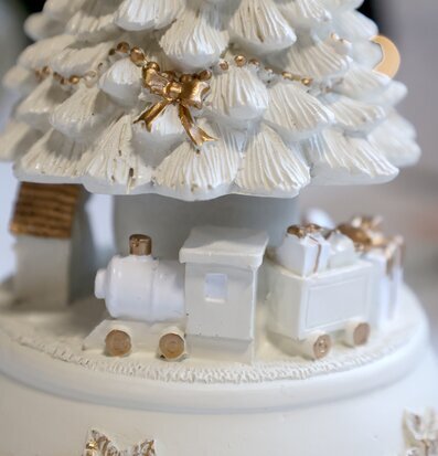 Bild av detaljrik speldosa med gran, tåg och gulddetaljer