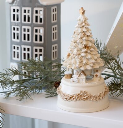 Bild av harmonisk juldekoration med speldosa och vinterhus