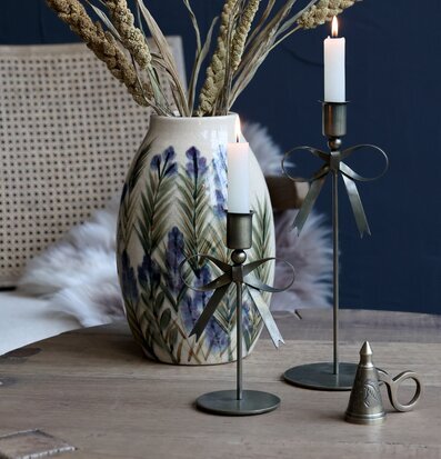 Bild av stilleben med vas, ljusstakar och lantlig inredning