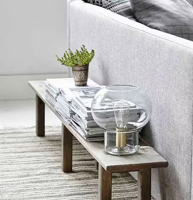 Lampa Mush från House Doctor på smalt bord med tidningar