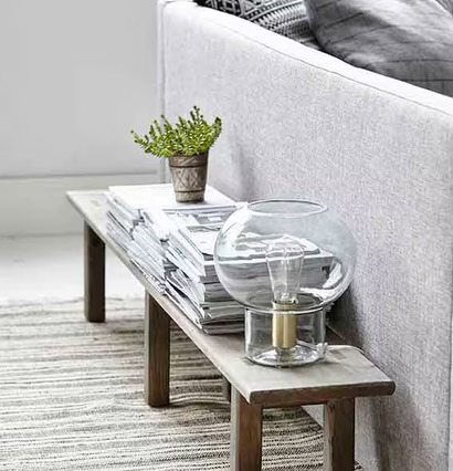 Lampa Mush från House Doctor på smalt bord med tidningar