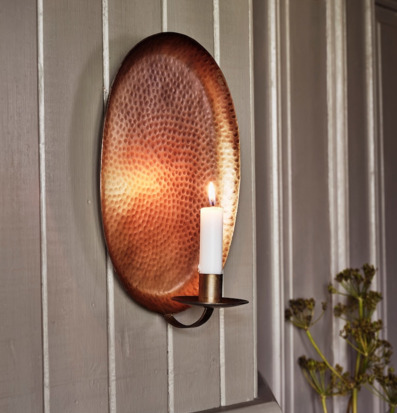 Bild av väggljusstake i antik mässing på pärlspontpanel