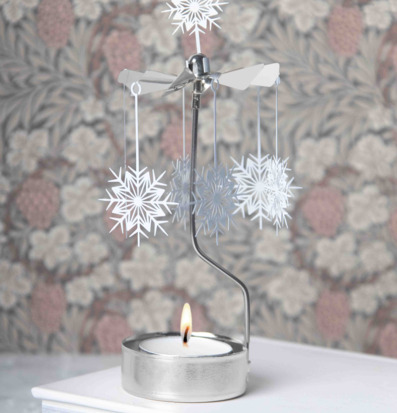 Bild av snurrande änglaspel med vita snöstjärnor och ljus