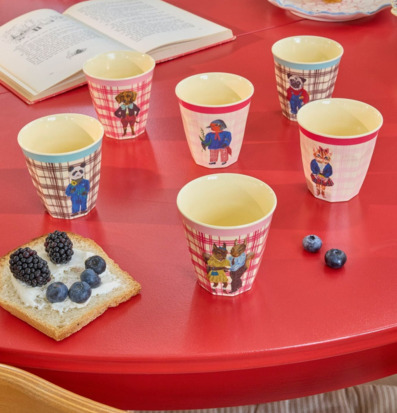 Bild av lekfull dukning med färgglada barnmuggar och frukt