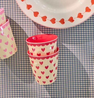 Bild på dukat bord med röda hjärtmuggar och rutigt tyg