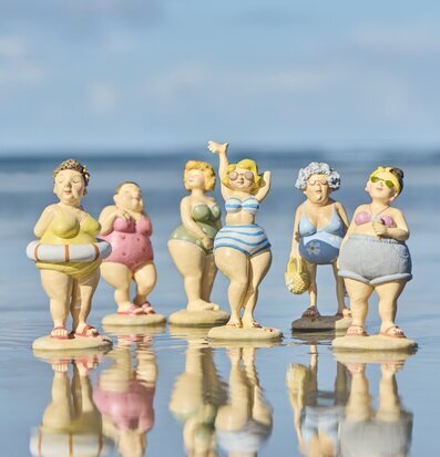 Foto: Strandfigurer i pastell på spegelblank sandyta