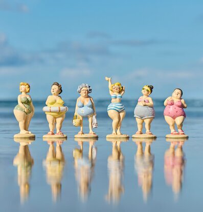 Bild: Sex badfigurer på spegelblank strand i blått