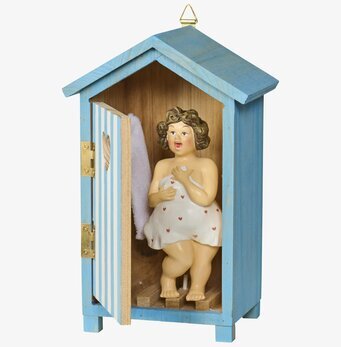 Foto: Blå strandhytt i trä med öppen dörr och dam