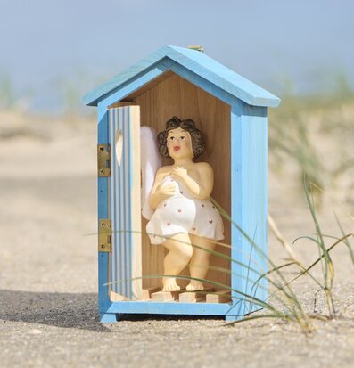 Foto: Miniatyr strandhus i blått med figur på sand