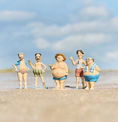 Foto: Fem badfigurer på stranden vid vattenlinjen