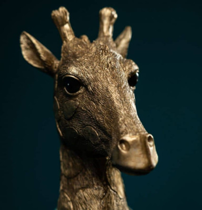 Foto: Närbild av bronsfärgad giraffskulptur i metallfinish