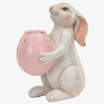 Foto: Sittande hare med rosa ljushållare på vit bakgrund