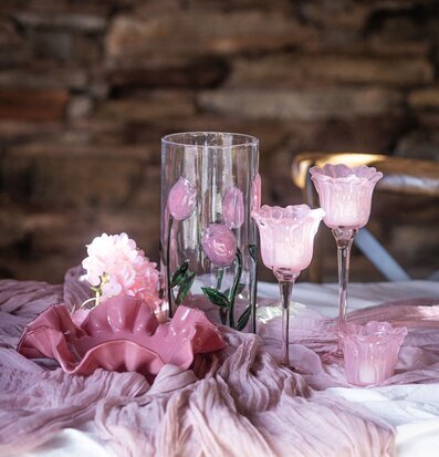 Foto: Rosa stillben med blomskål, glasvas och lyktor