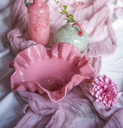 Foto: Rosa blombladsskål i stilleben med vaser, tyg