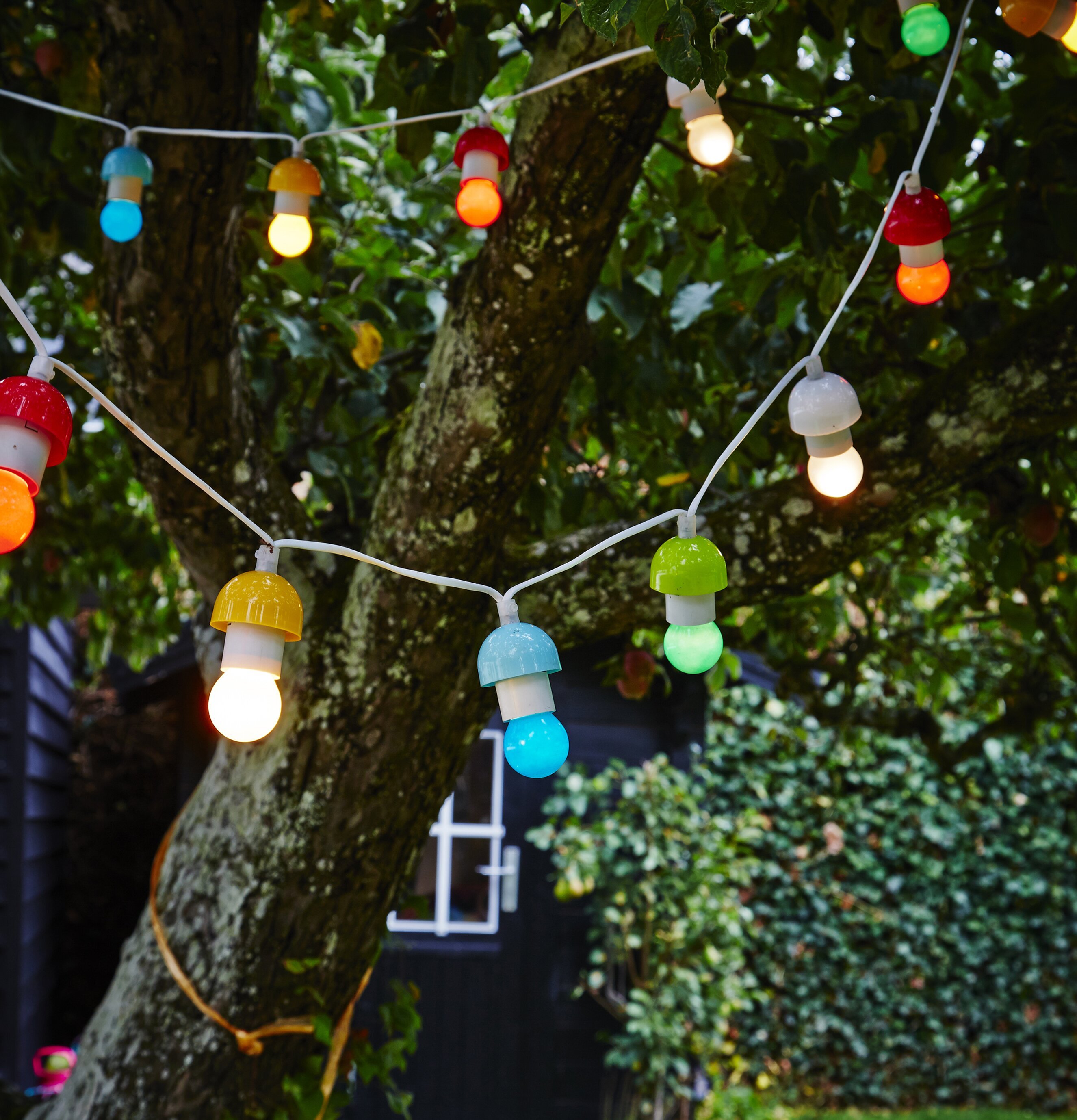 Ljusslinga - 12 Lampor från Rice upphängd i träd i trädgård