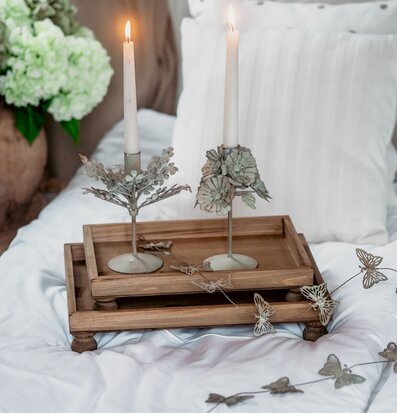 Bild: Träbrickor med ljus och fjärilar på sängtäcke