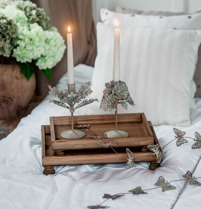Bild: Träbrickor på bäddad säng med ljus och dekoration