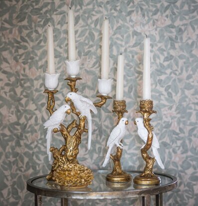 Foto: Ljusstakar med fåglar i guld på spegelbordet