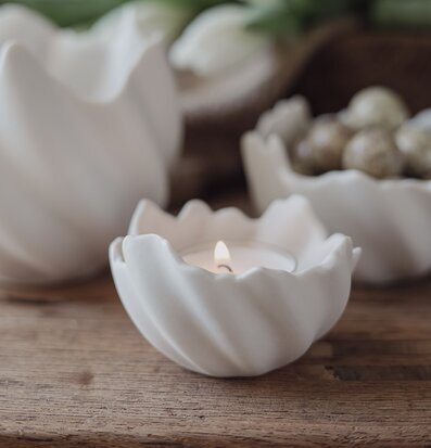 Foto: Äggskalsformad ljuslykta på träbord, tulpaner