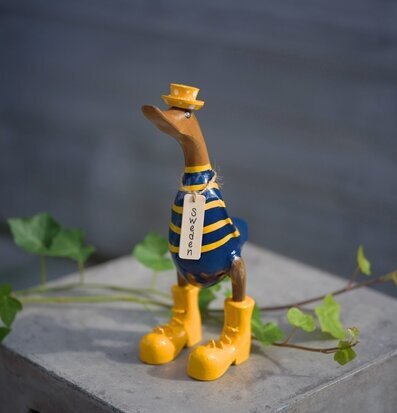 Foto: Träanka i blått och gult på betongblock murgröna