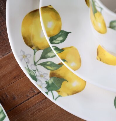 Foto: Citrusmönstrad dukning i keramik på träbord﻿