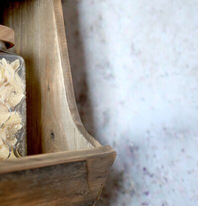 Bild: Närbild på trähylla med glasdetalj och vägg