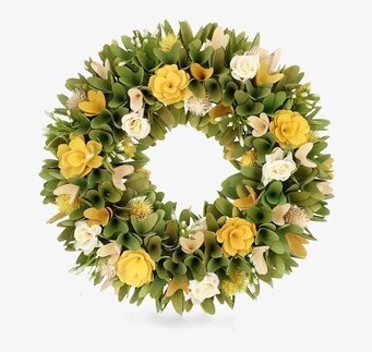 Foto av grön krans med gula och vita rosor på vitt bakgrund