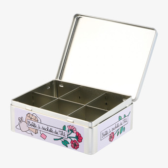 Foto: Öppen plåtburk för te med fyra fack, vit bakgrund