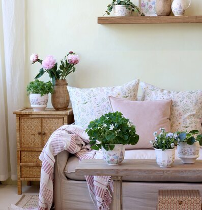 Foto: Ljust vardagsrum med blommiga krukor & textil