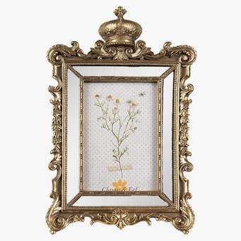 Foto: Ornamenterad guldram med krona på vit bakgrund