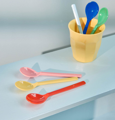 Foto: Färgstarka teskedar och gul mugg på blå yta